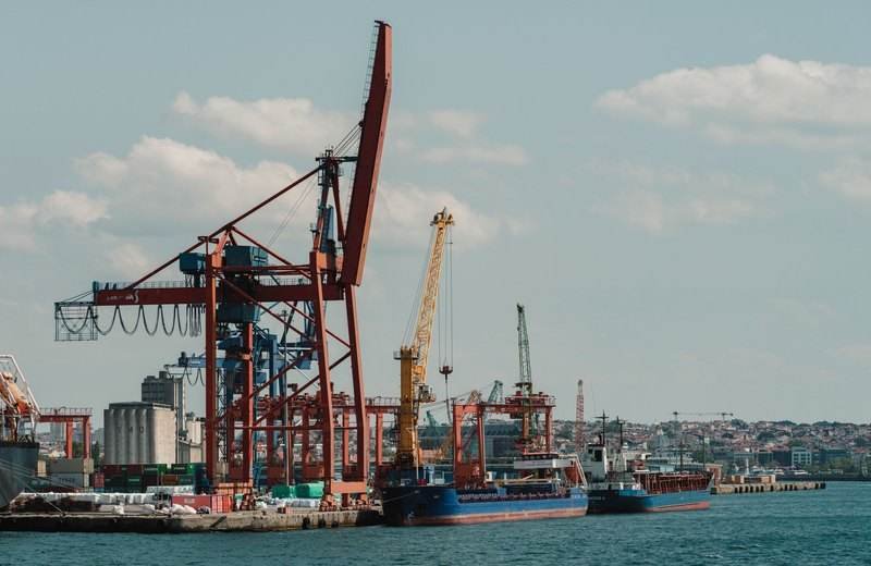 Puerto de carga con buques y grúas bajo un cielo despejado