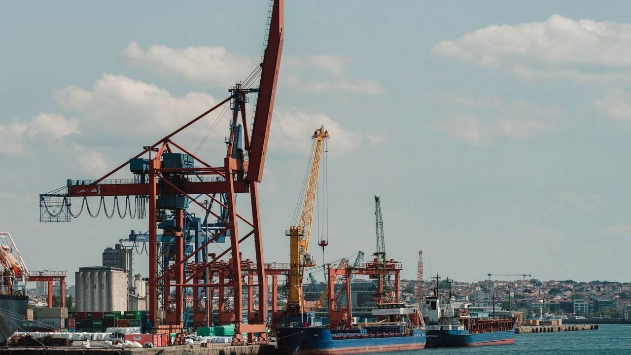 Puerto de carga con buques y grúas bajo un cielo despejado