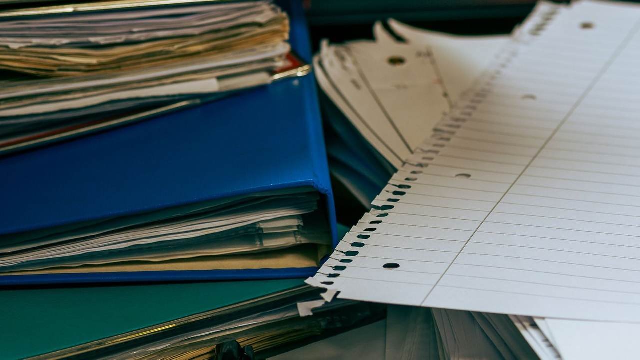 Escritorio ordenado con pilas de papeles y carpetas
