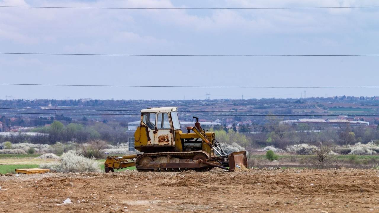 Topadora vieja abandonada en un campo baldío bajo un cielo nublado