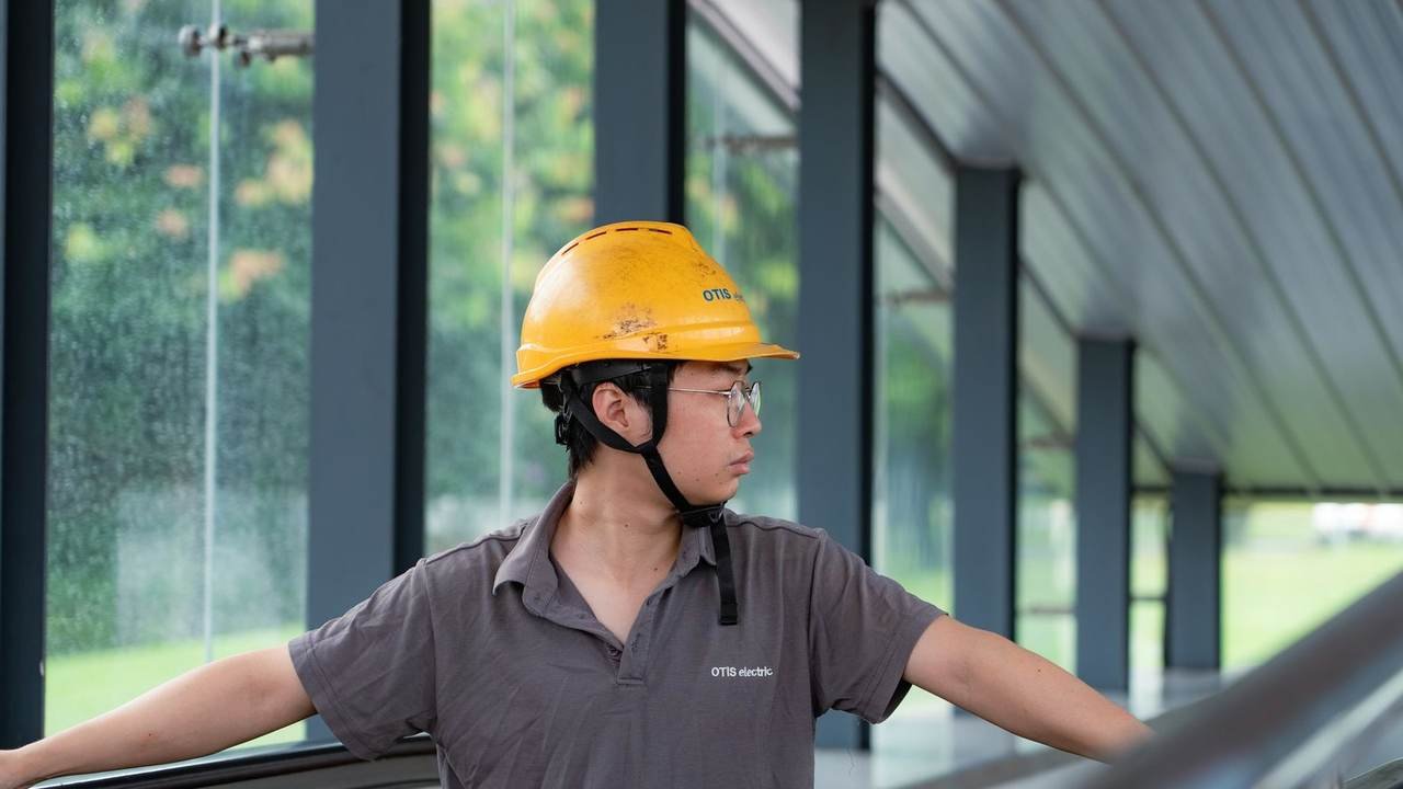 Trabajador con casco recorriendo e inspeccionando una planta industrial