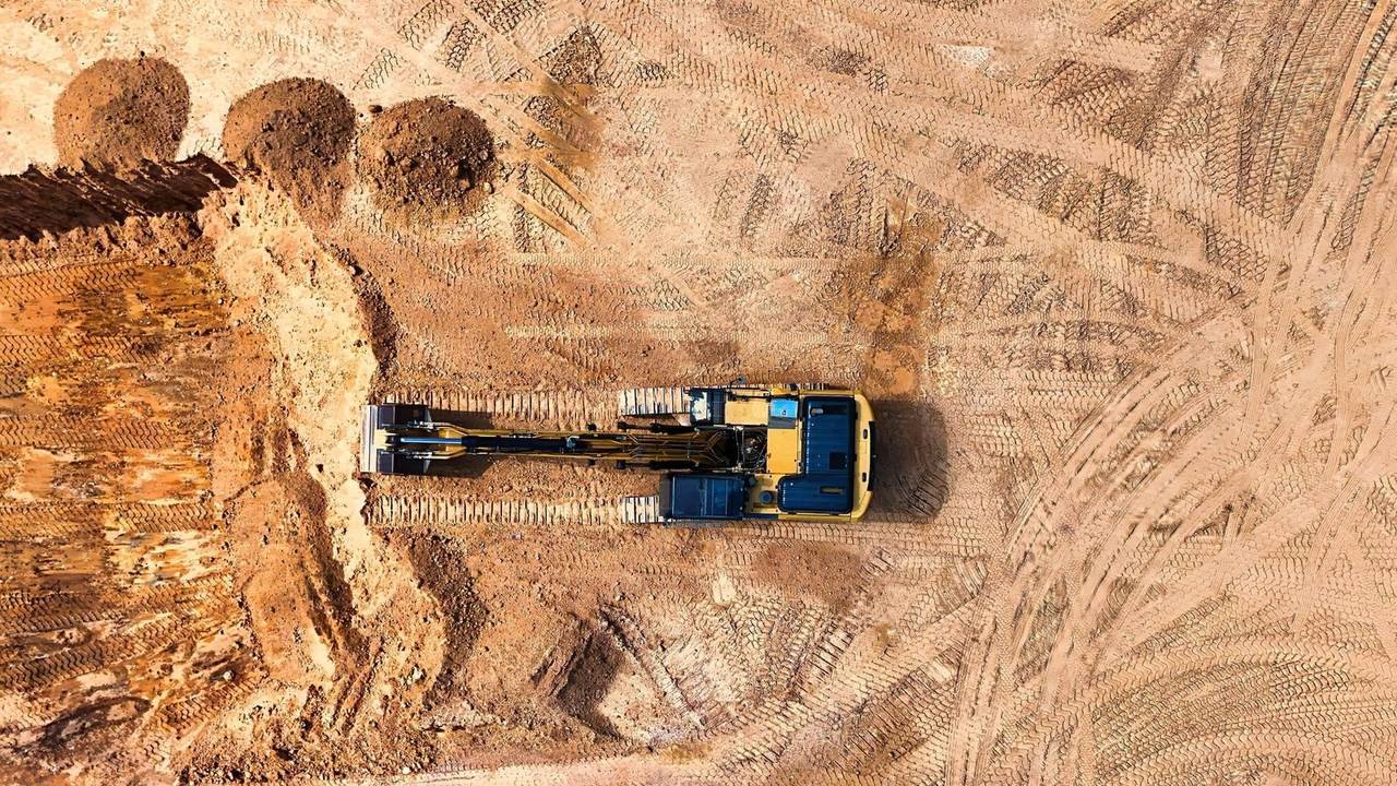 Vista aérea de una excavadora en un terreno de obra despejado