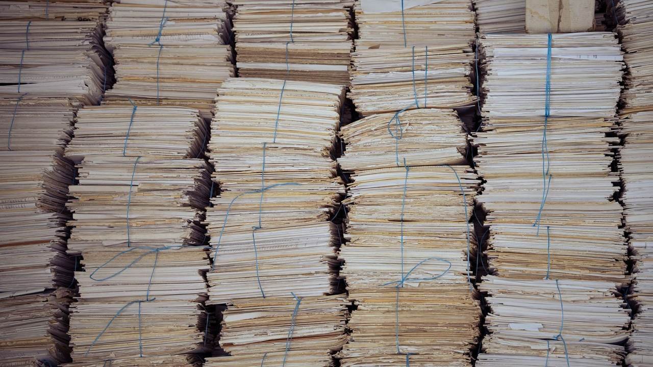 Pilas de legajos encuadernados y ordenados en un archivo