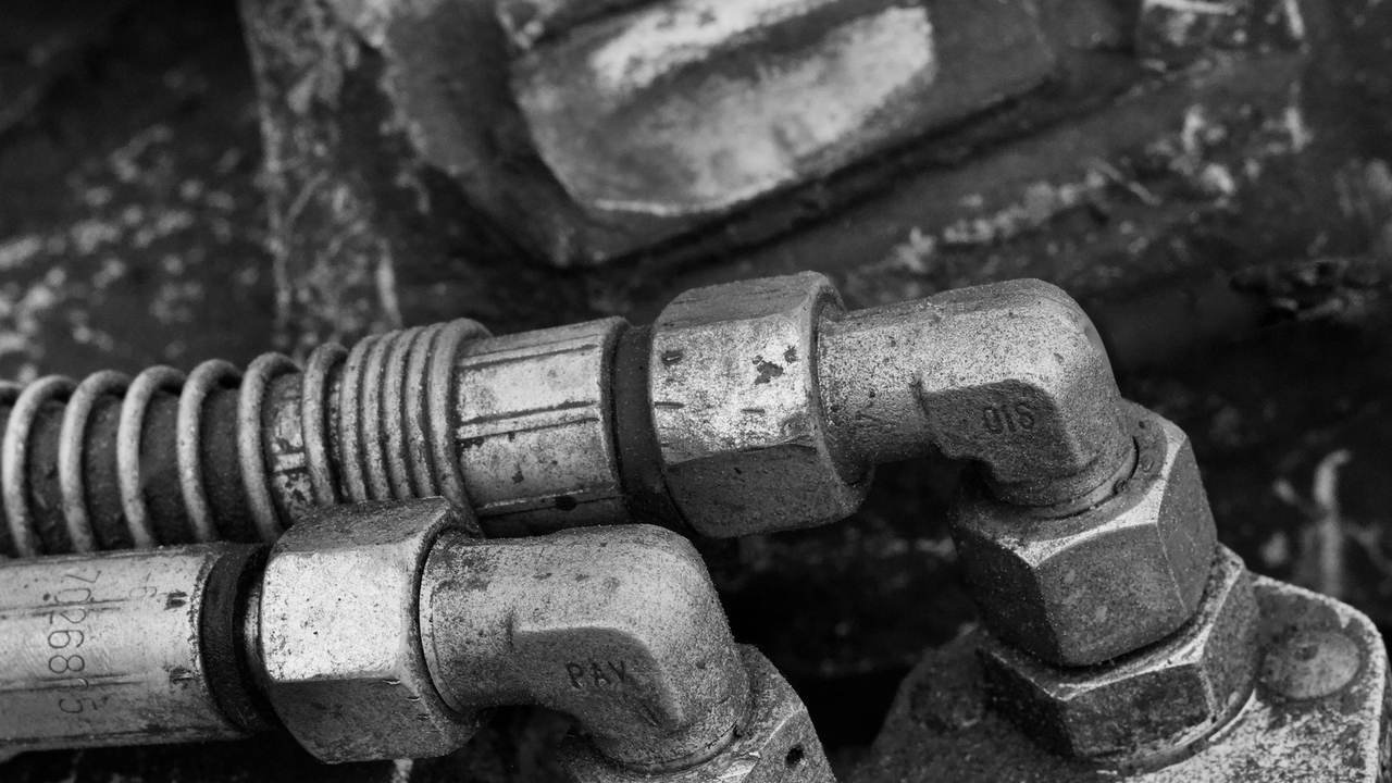 Detalle de componentes metálicos y conexiones hidráulicas de una máquina