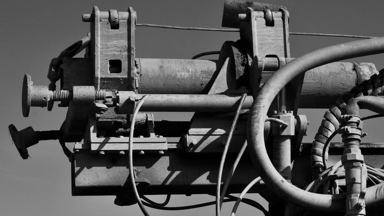 Cañerías y engranajes de maquinaria industrial, en blanco y negro