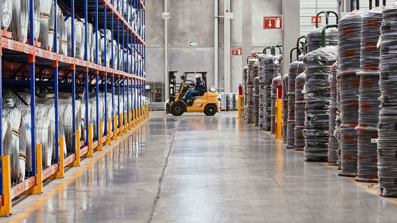 Autoelevador operando en un depósito industrial con mercadería apilada