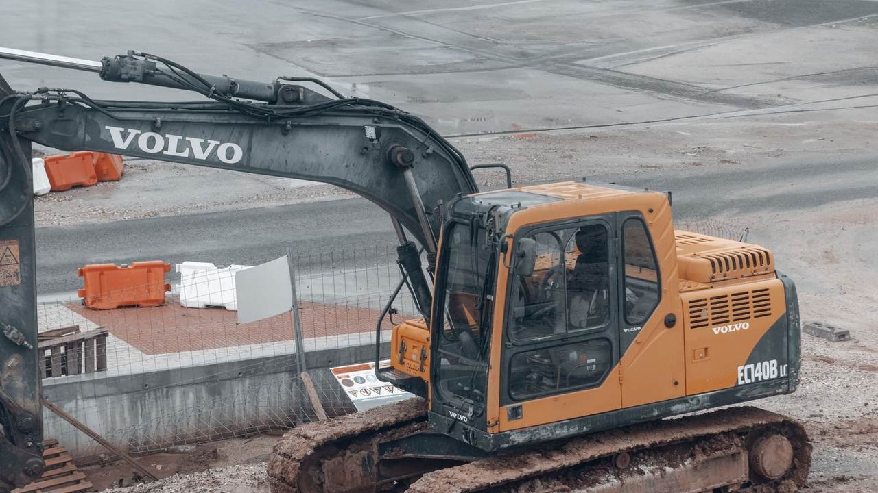 Excavadora Volvo amarilla en obra, con el tren de rodaje embarrado