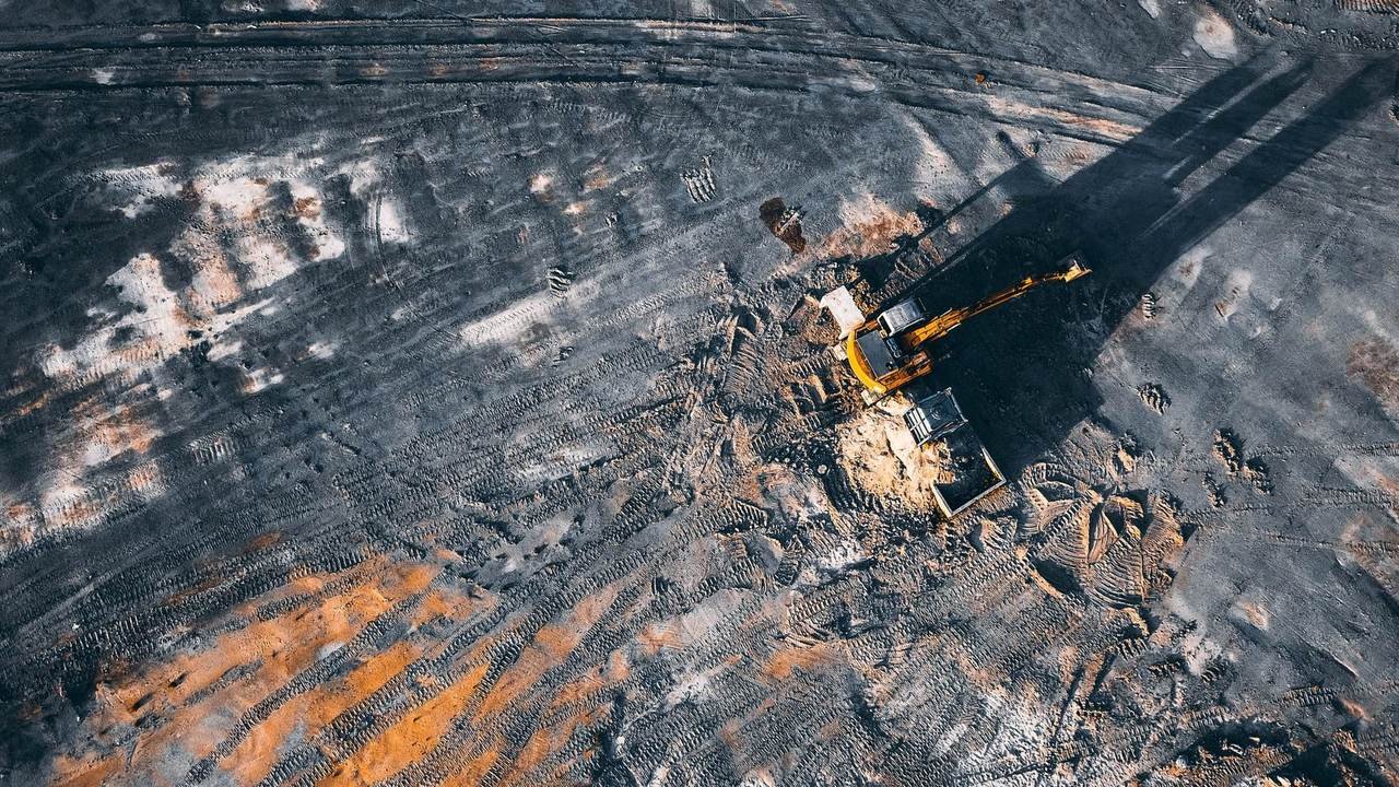 Vista aérea de una excavadora trabajando sobre una playa de carbón