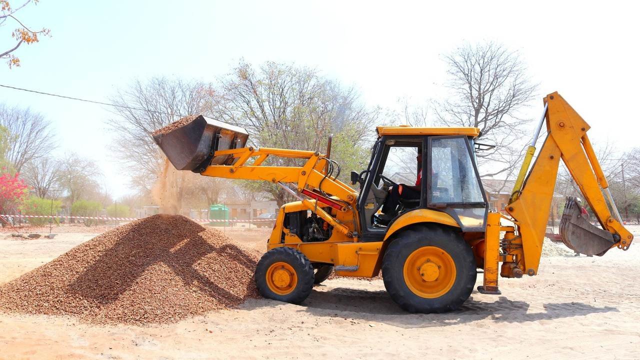 Excavadora amarilla moviendo grava en una obra a cielo abierto
