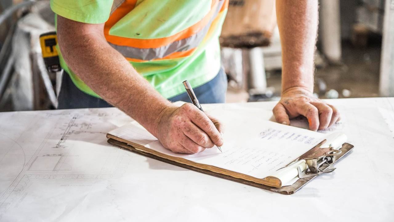 Operario tomando notas en una planilla dentro de una obra