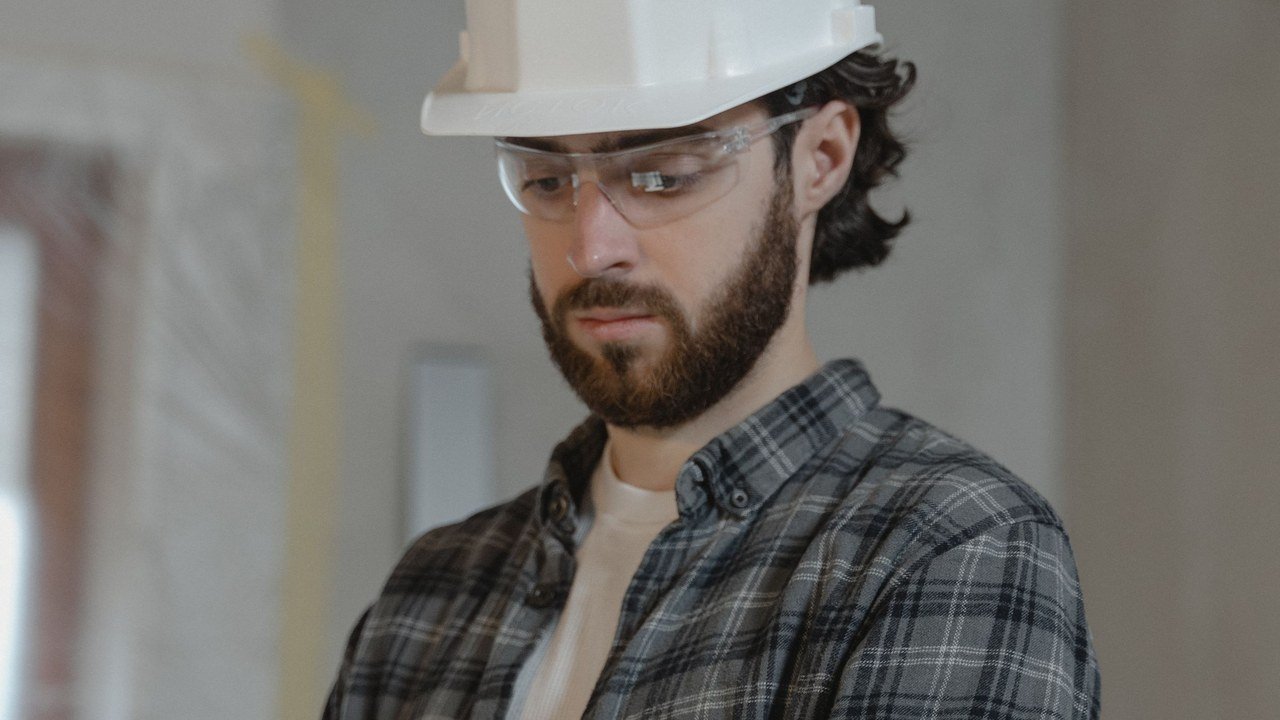 Ingeniero con casco revisando planos de obra