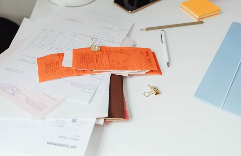 Escritorio con comprobantes, documentos y útiles de oficina