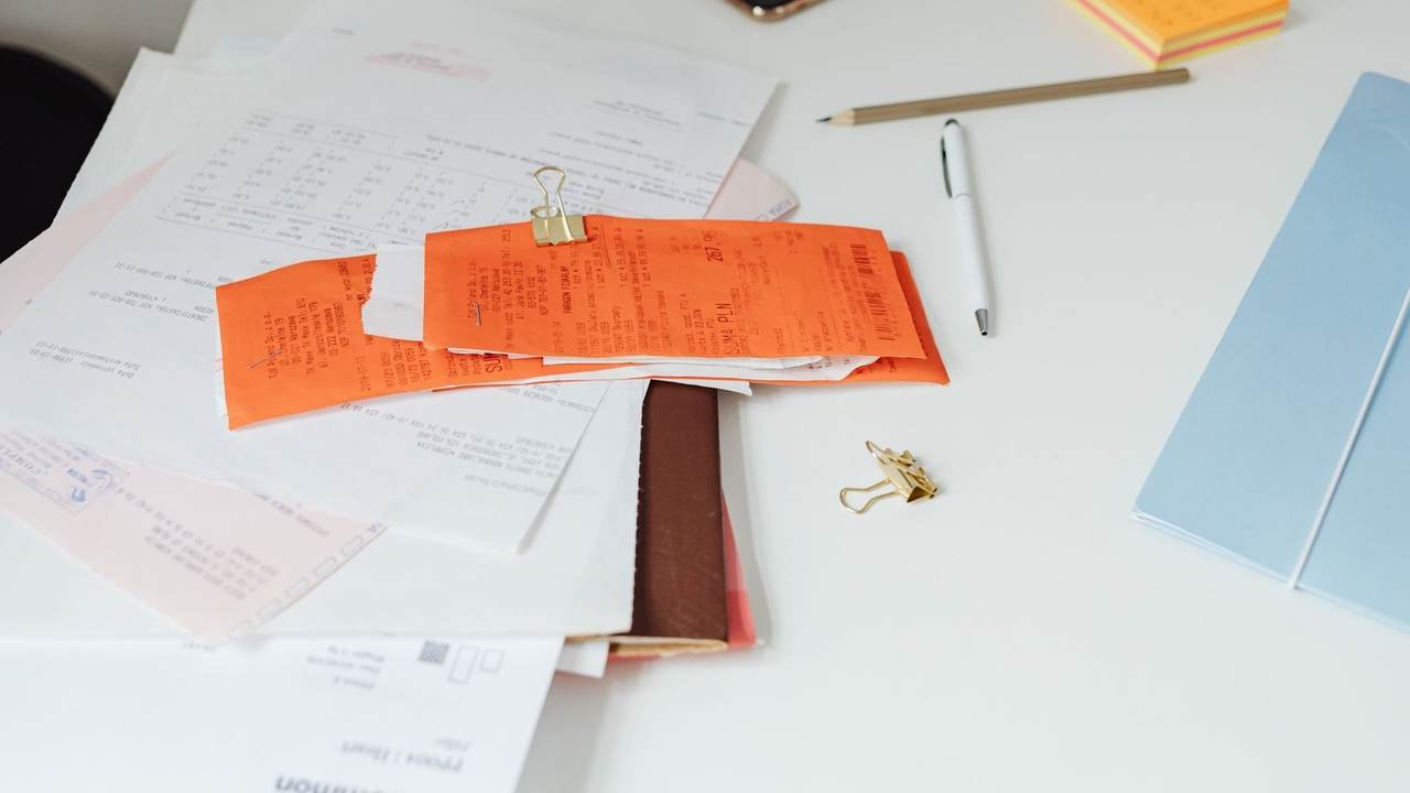 Escritorio con comprobantes, documentos y útiles de oficina