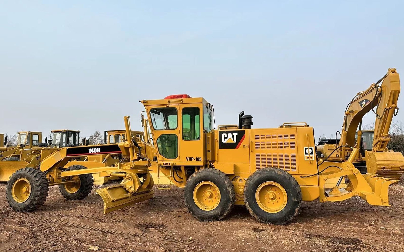 Motoniveladoras Caterpillar usadas alineadas en el patio de un exportador chino